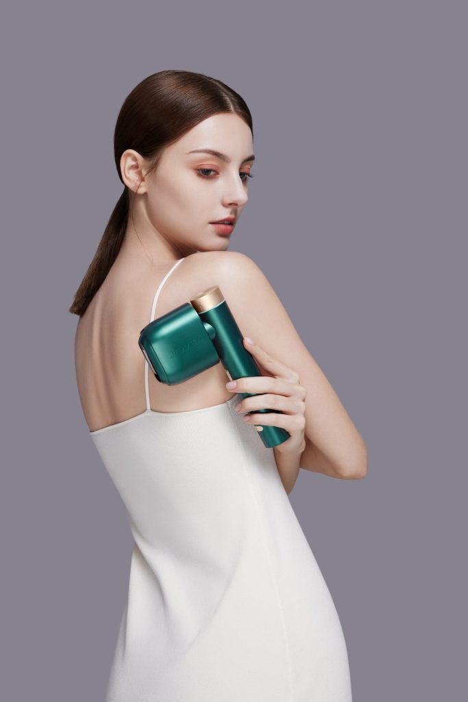 A model in a sleek dress subtly presents a IPL hair removal device, a symbol of modern beauty technology.